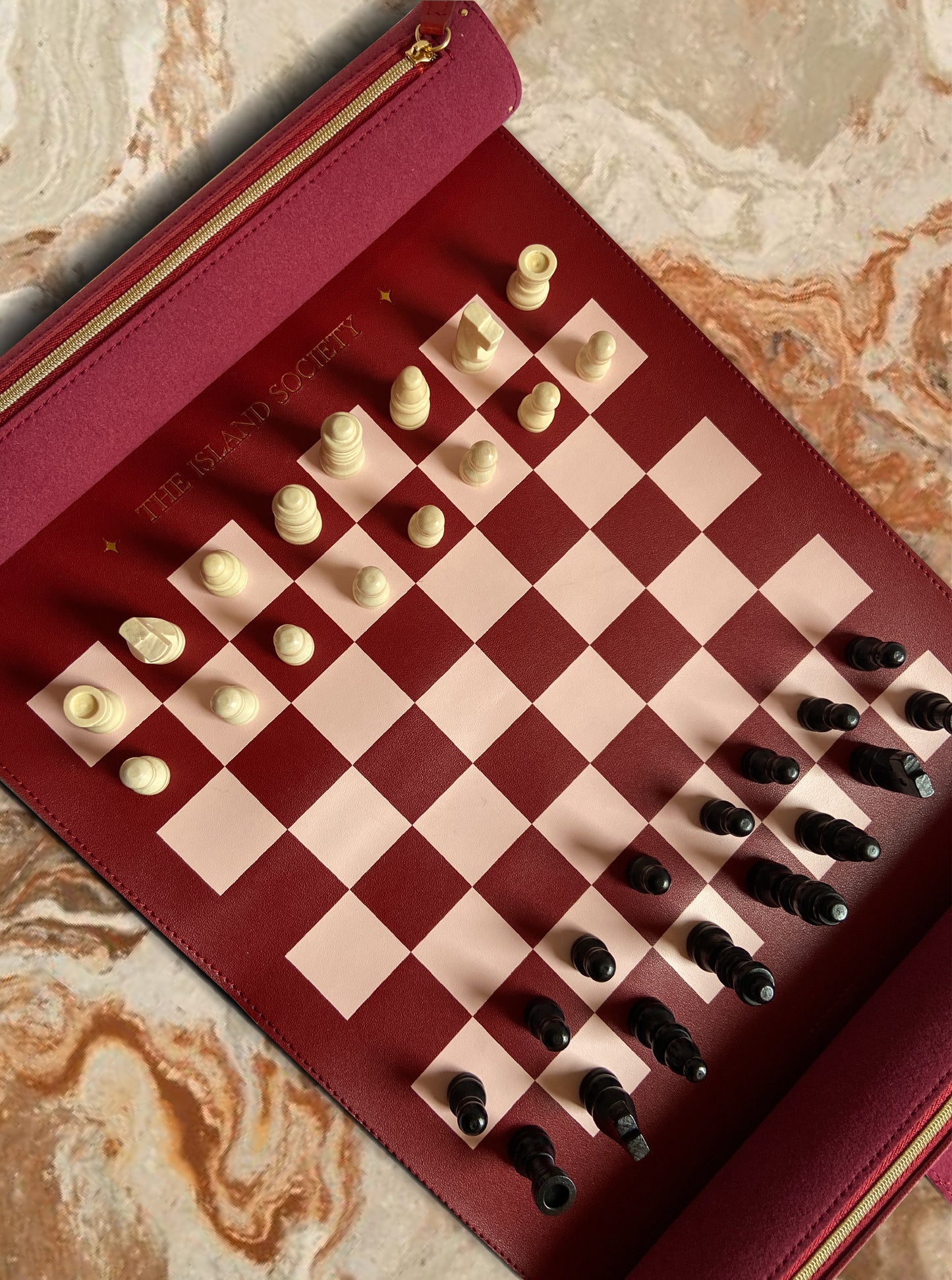 Checkers board with red and gold border on a marble surface