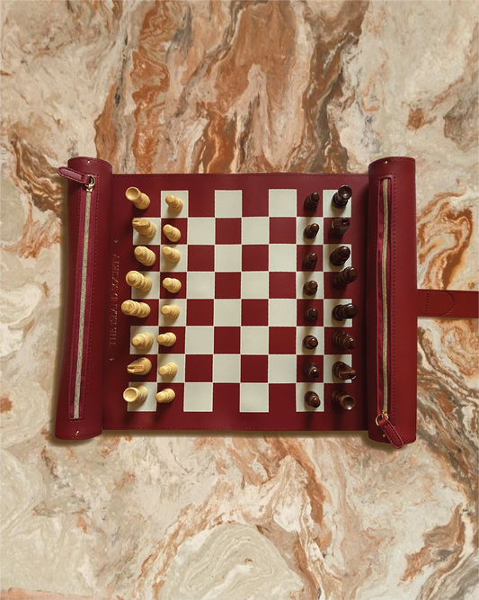 luxury burgundy roll up chess set on a marble table