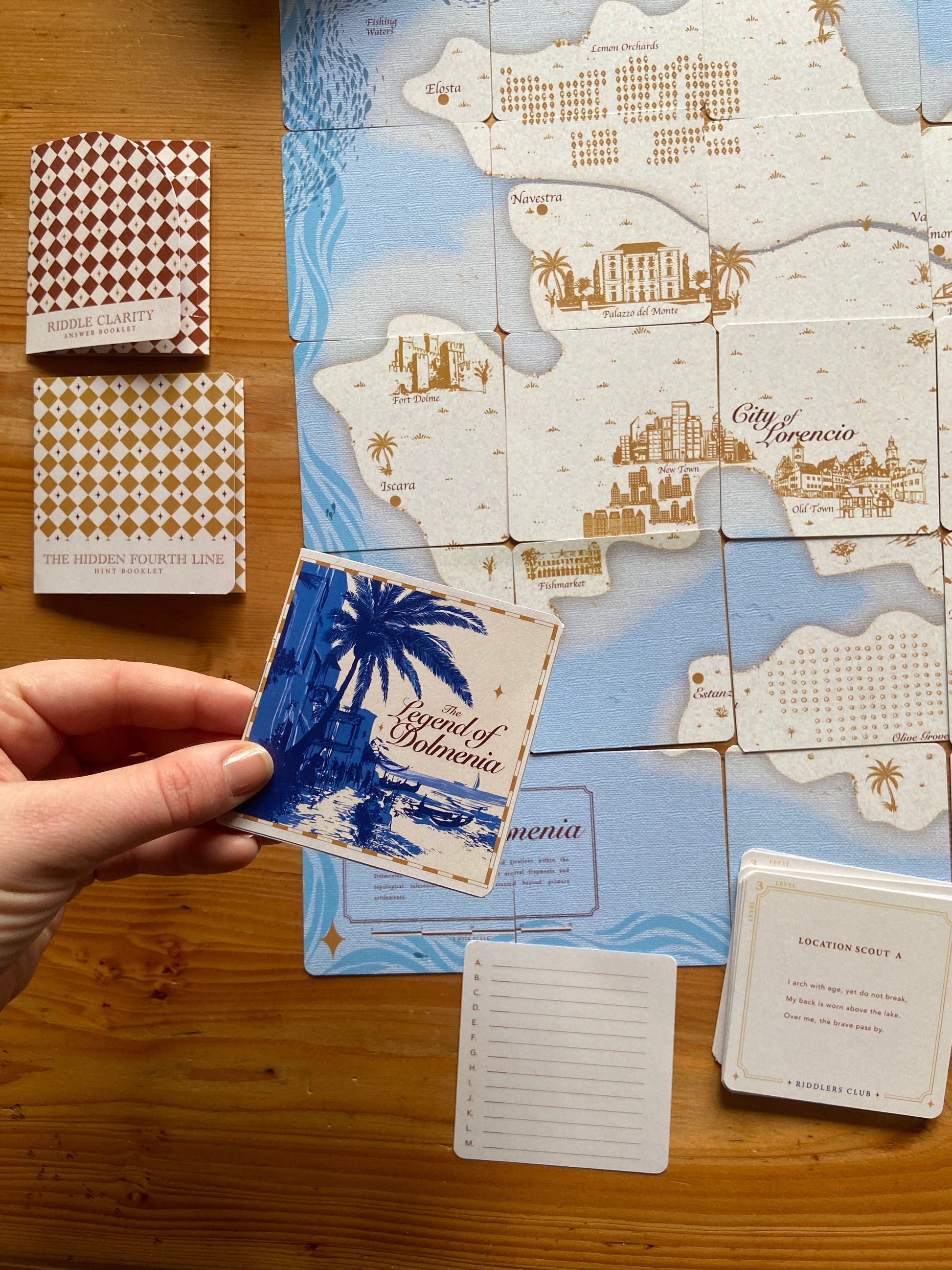 Board game pieces with a map and cards on a wooden surface Instruction booklet 